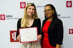 A student, accompanied by a faculty member, receives a School of Liberal Arts scholarship.